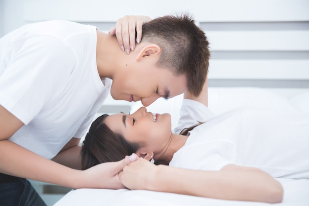 Happy Asian couple on the bed at home