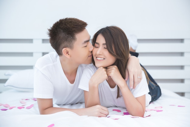 Free photo happy asian couple on the bed at home