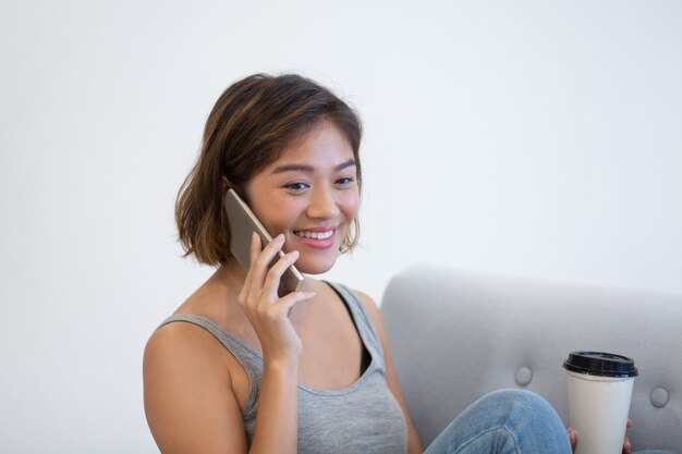 Счастливый азиатский фрилансер смеется на телефоне