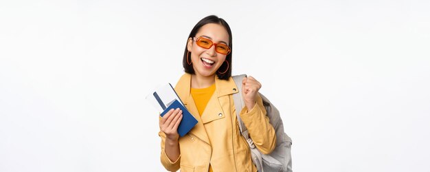 여권과 비행기표 배낭을 어깨에 메고 휴가를 가는 행복한 아시아 소녀