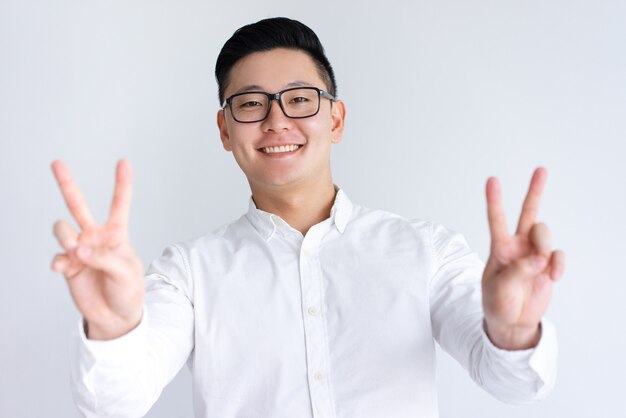Happy Asian man showing two victory signs
