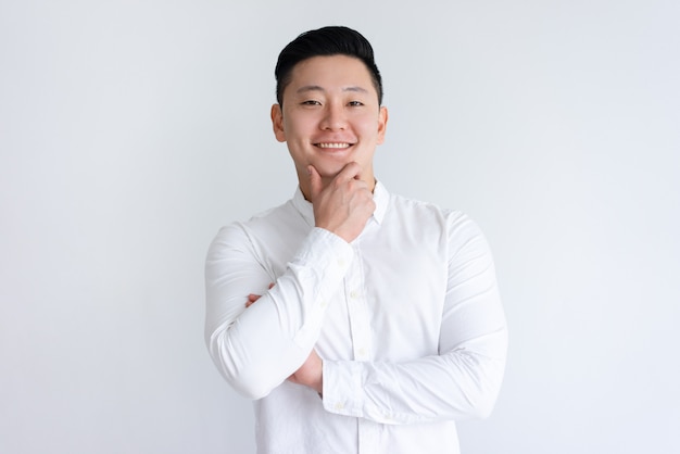 Free photo happy asian man touching chin and looking at camera