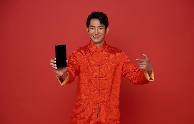 Happy Asian man wearing traditional dress showing mobile phone blank screen