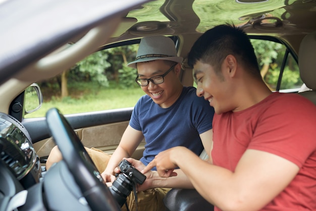 車に座って、一緒にカメラを見て幸せなアジア人