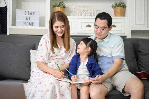 Premium Photo | Happy asian parent teaching little cute daughter to do  homework and drawing picture together at home.