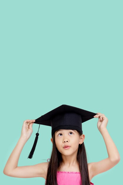 복사 공간이 있는 행복한 아시아 여학생 졸업 모자를 쓴 학생 자녀 졸업
