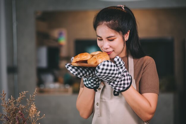 幸せなアジアの女性が自宅で自家製パン屋を調理中小企業のコンセプトを起動します。