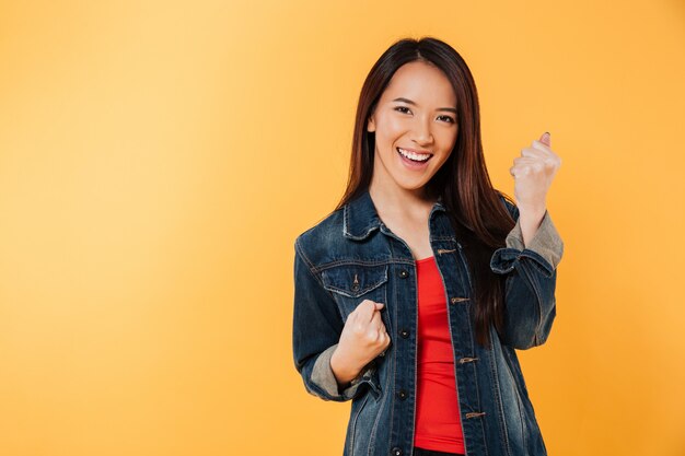 Happy asian woman in jacket rejoice and looking at camera