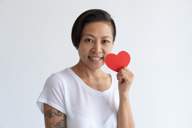 Happy Asian woman posing with paper heart