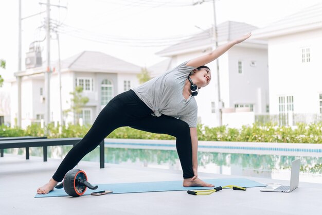 幸せなアジアの女性の自宅での朝のストレッチ運動とヨガのトレーニング