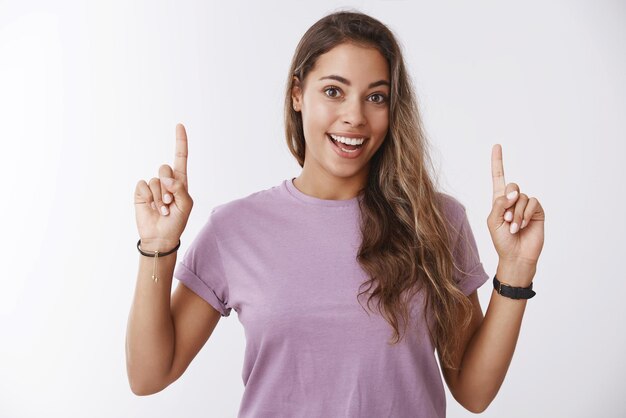 Happy attractive  woman pointing fingers up