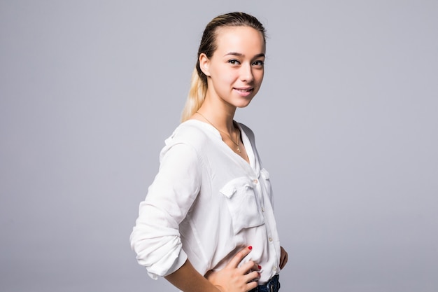 Happy attractive woman standing over gray wall and