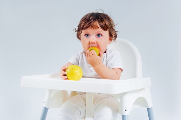 Happy baby boy sitting and eating