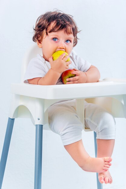 Happy baby boy sitting and eating