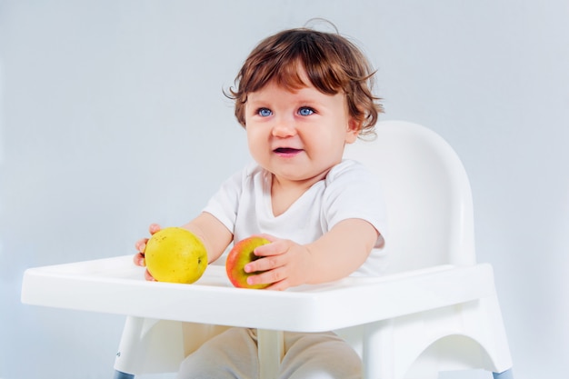 Happy baby boy sitting and eating