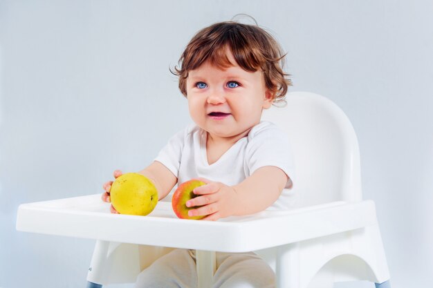 Happy baby boy sitting and eating