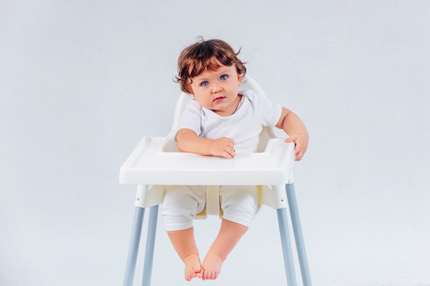 Happy baby boy sitting on studio background