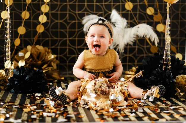 Happy baby eating cake on her first birthday party. Cakesmash for little girl