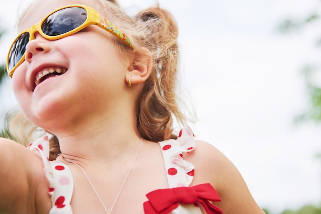 Счастливая девочка в летних солнечных очках.