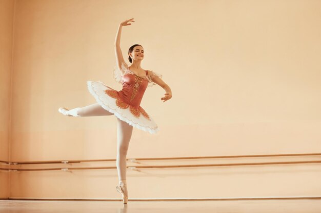 Happy ballerina rehearsing choreography while dancing in a studio Copy space