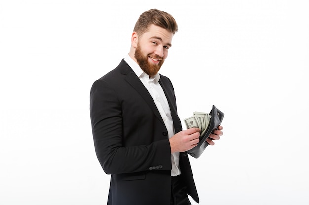 Happy bearded business man holding purse with money