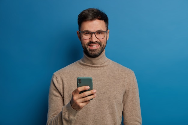 幸せなひげを生やした男性ブロガーは、ブログに新しいフォロワーがいることを喜んでいます