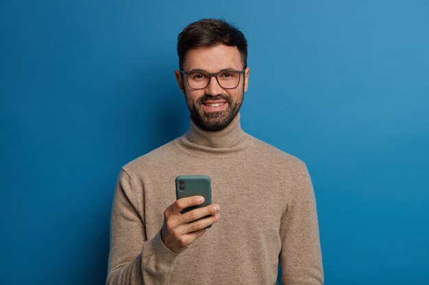 Happy bearded male blogger rejoices having new followers in blog