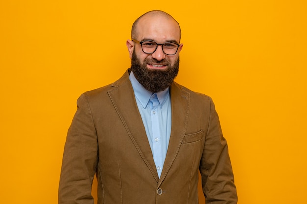 Happy bearded man in brown suit wearing glasses looking smiling cheerfully