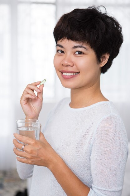 Happy Beautiful Asian Woman Taking Pill