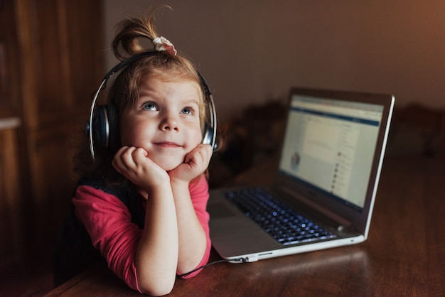 Bello bambino felice in cuffie che ascolta la musica.