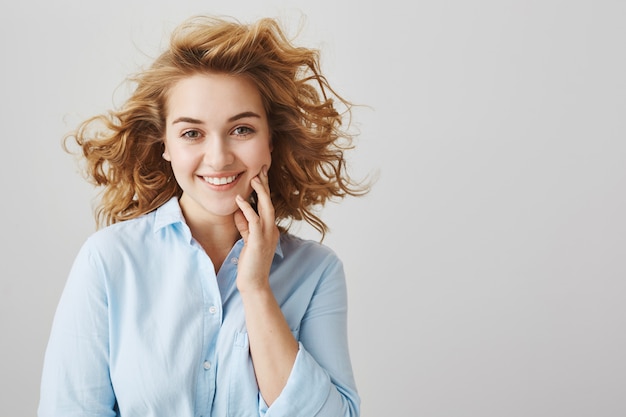 Happy beautiful and dreamy girl with curly short hair smiling