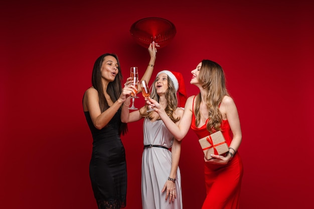 Happy beautiful female friends posing together while making a toast