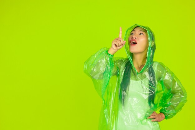 Happy beautiful girl, wearing green clothes, umbrella and coat. rainy day.