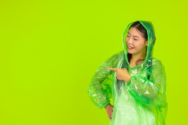 Happy beautiful girl, wearing green clothes, umbrella and coat. rainy day.