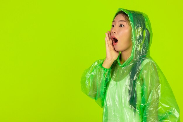 Happy beautiful girl, wearing green clothes, umbrella and coat. rainy day.