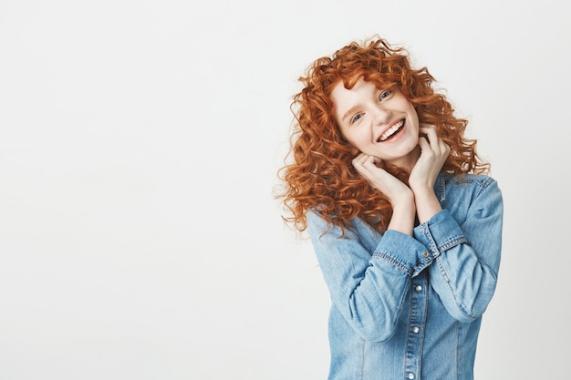 Happy beautiful girl with curly red hair smiling . Copy space.