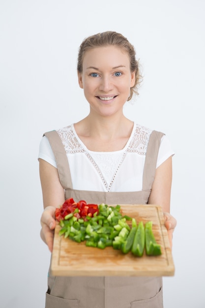 Happy beautiful woman holding cutting board