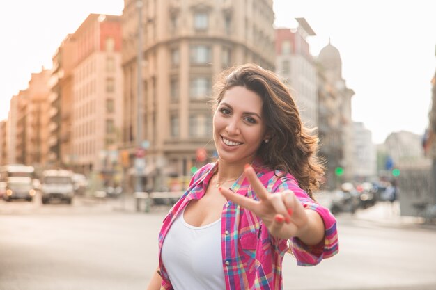 Happy beautiful woman showing peace sign