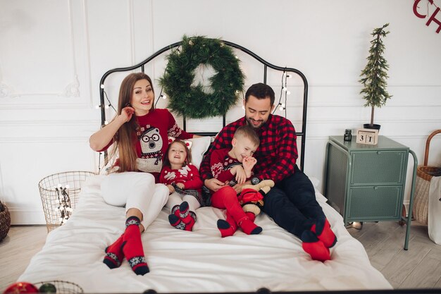 Foto gratuita felice bella donna in abito bianco in posa vicino all'albero di natale