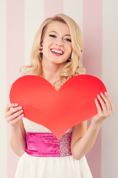 Free photo happy beautiful woman with big red heart