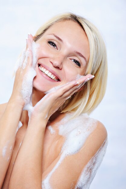 Happy beautiful young woman relaxing in bathroom
