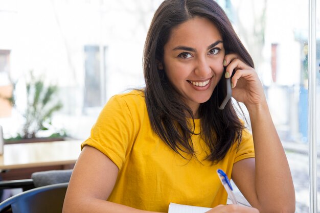 Happy beautiful young woman talking on smartphone