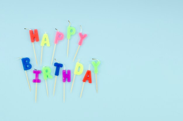 Happy birthday colorful candles on blue background