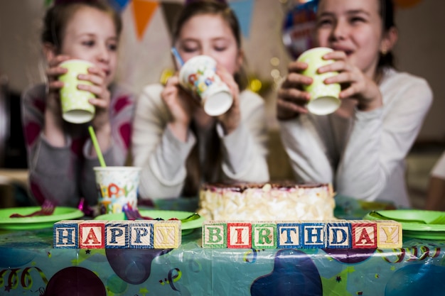 Happy birthday writing near drinking girls