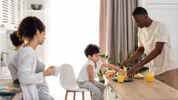 Free photo happy black family setting the table for eating