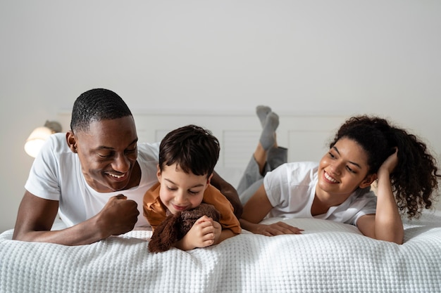 無料写真 ベッドに横たわっている間笑顔幸せな黒人家族