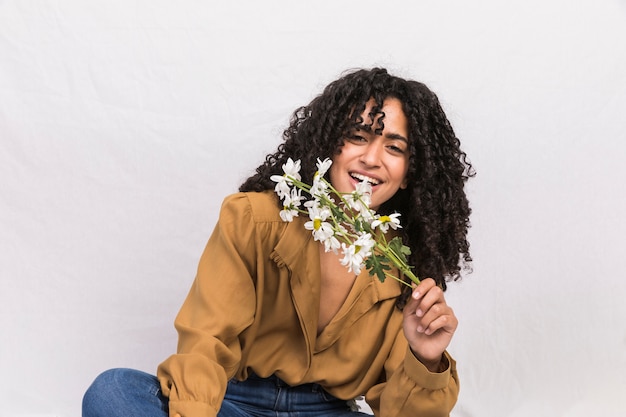 Free photo happy black woman holding daisy flowers