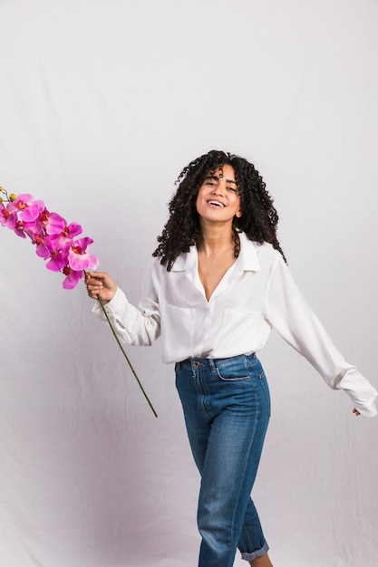 Happy black woman holding pink flower 