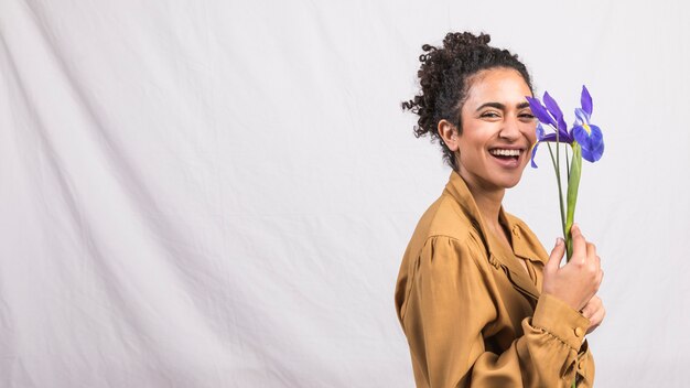 Happy black woman standing with flower