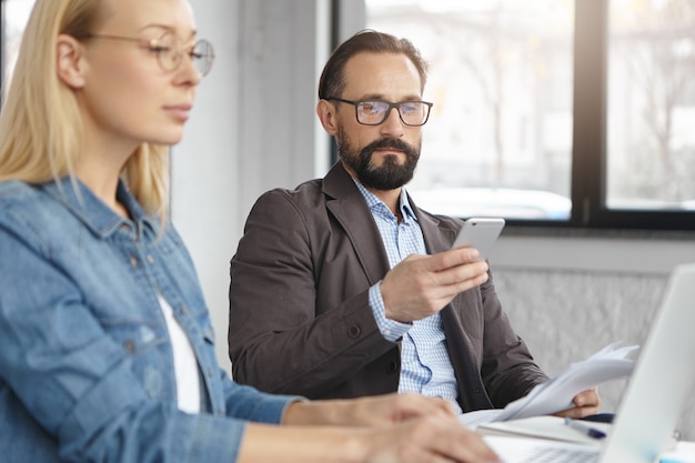 Free photo happy blonde female manager has conversation with male colleague